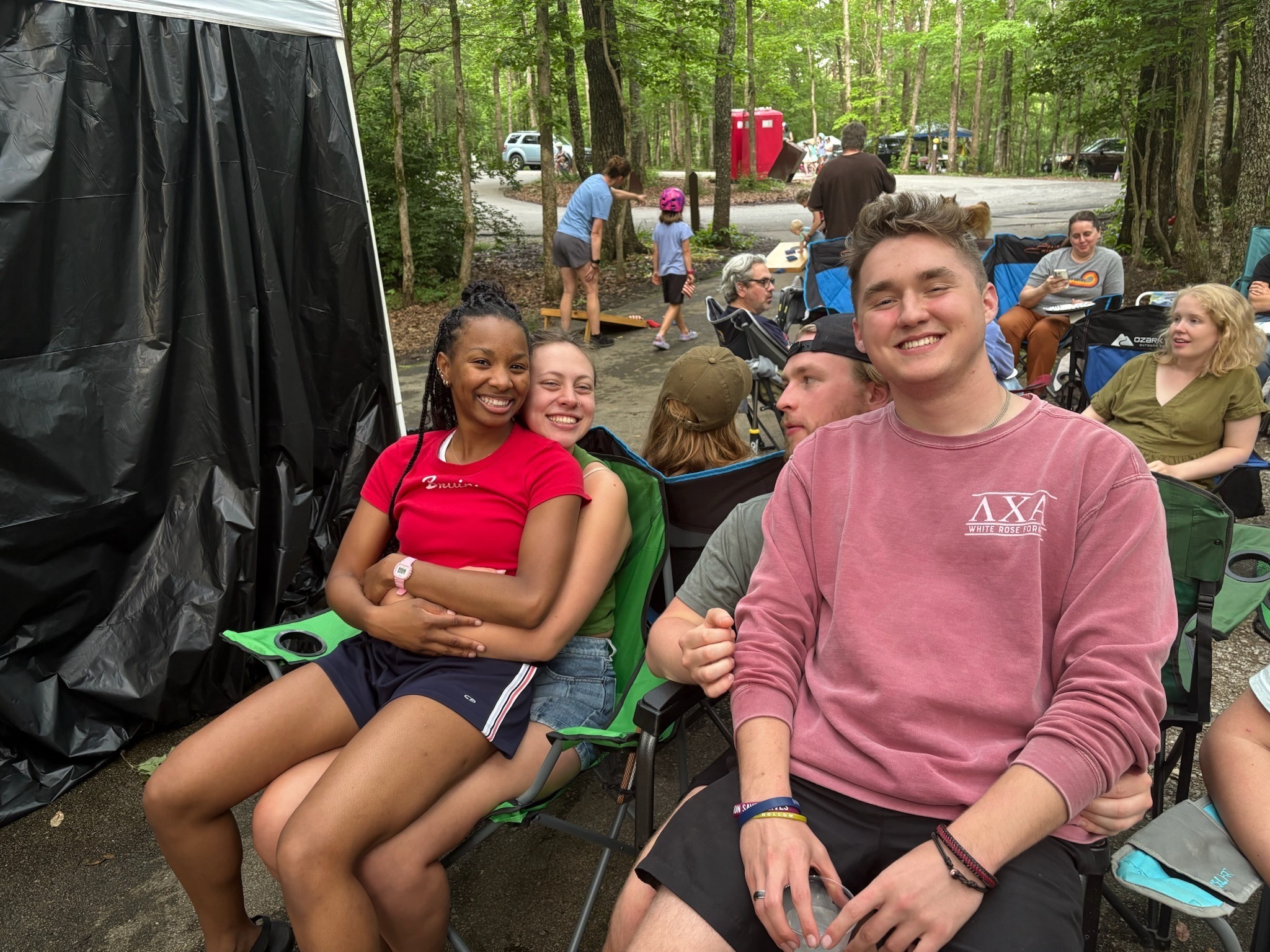 2025 FCF Lara 30 A gaggle of people sit in camp chairs in a campsite reserved for dining
